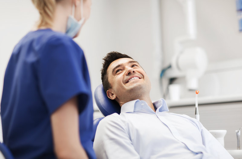 female dentist with happy male patient at clinic in Amherst, NH<br />
